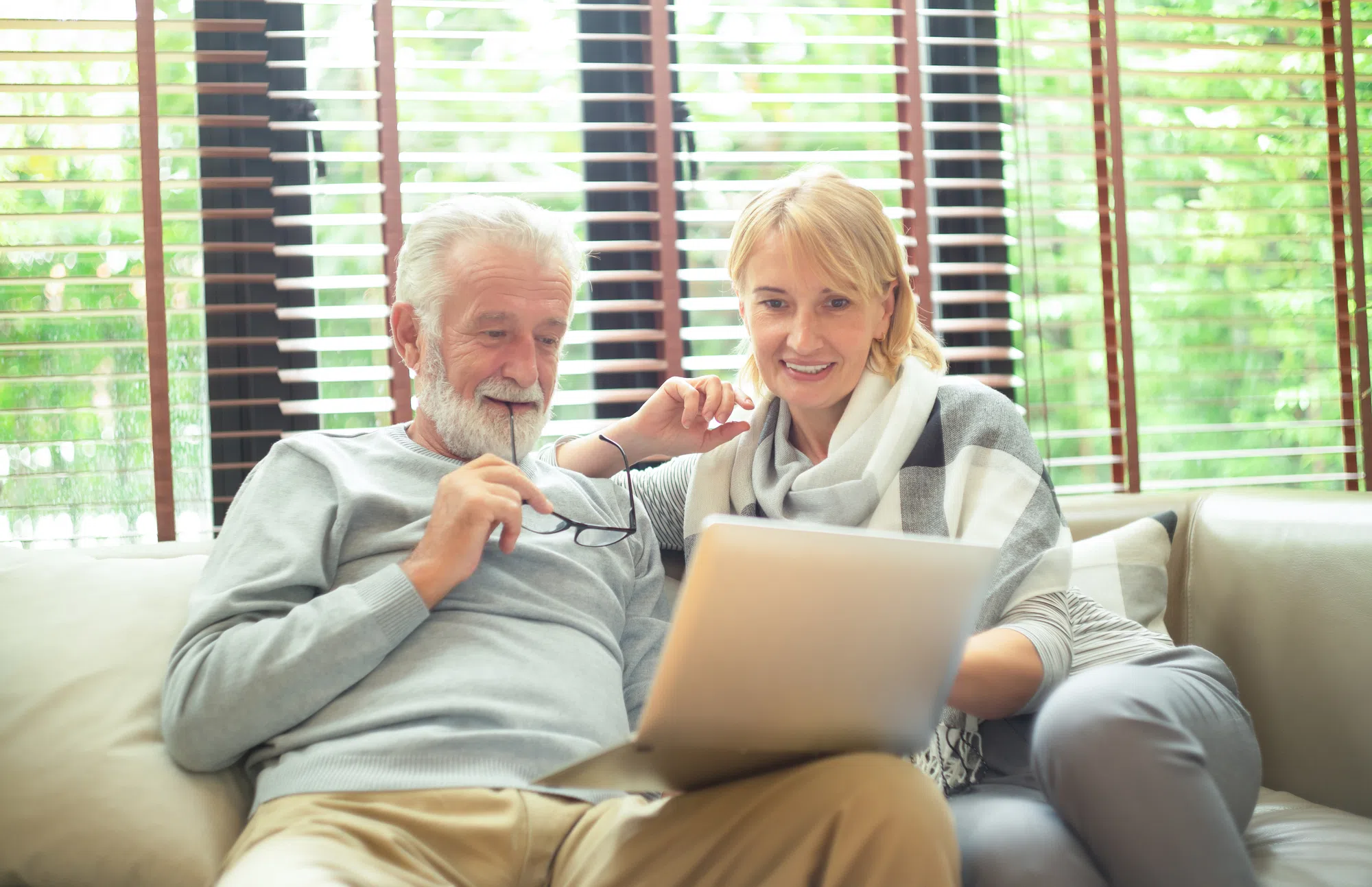 Seniorenpaar bei der Immobiliensuche am Laptop